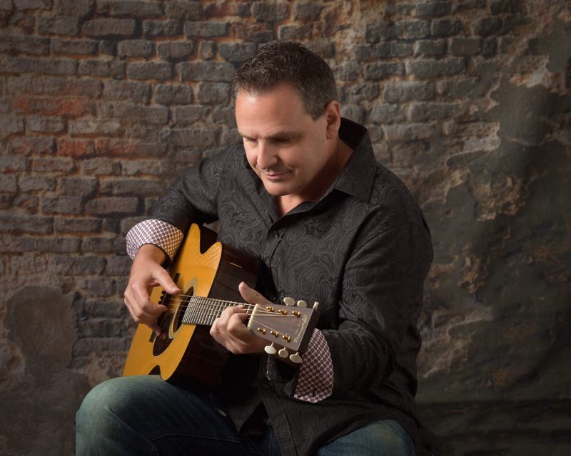 Jim Botsford performing with his acoustic guitar